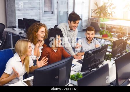 Aufgeregt Studenten lesen gute Nachrichten zusammen auf Bildschirm Stockfoto