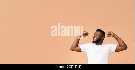 Selbstbewusster Black man, der Muskeln in Studio-Umgebung beugt Stockfoto