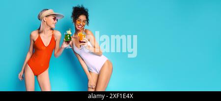 Zwei Frauen In Badeanzügen Trinken Auf Blauem Hintergrund Stockfoto