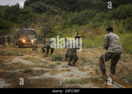 US-Marines und Marinekorpsmänner mit dem 1st Marine Regiment, 1st Marine Division, ziehen einen Humvee während des jährlichen Corpsman Cup der Division im Marine Corps Base Camp Pendleton, Kalifornien, 14. Juni 2024. Der Corpsman Cup ist eine langjährige Tradition innerhalb des 1st MARDIV, die medizinisches Personal aus der gesamten Division zusammenbringt, um durch eine Reihe von physischen Herausforderungen und technischen Bewertungen konkurrieren zu können. (Foto des U.S. Marine Corps von CPL. Anita Ramos) Stockfoto