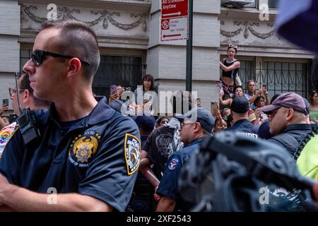 New York, Usa. 30. Juni 2024. Das NYPD verhaftet die Demonstranten, während die Menge während der Demonstration zusieht. Queere Pro-Palästina-Aktivisten blockierten die NYC Pride Parade in Manhattan. Die Demonstranten saßen in der Mitte der Paraderoute an der Christopher Street und am Waverly Place. Mehrere Verhaftungen wurden durchgeführt und die Parade wurde fortgesetzt, nachdem sie entfernt wurden. (Foto: Syndi Pilar/SOPA Images/SIPA USA) Credit: SIPA USA/Alamy Live News Stockfoto