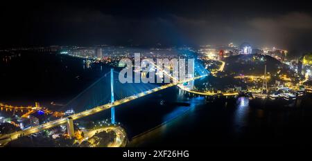 Aus der Vogelperspektive auf der Bai Chay-Brücke die Lichter schimmern zwei Halbinsel, die Hon Gai und Bai Chay in der Stadt Ha Long, Quang Ninh, Vietnam, verband Stockfoto