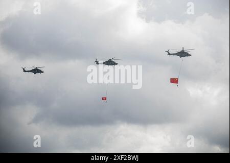Hongkong, China. Juli 2024. Hubschrauber mit den Flaggen von China und Hongkong am Himmel über dem Victoria Harbour. Anlässlich des 27. Jahrestages der Gründung der Sonderverwaltungsregion Hongkong fanden in der ganzen Stadt verschiedene Feiern und Veranstaltungen statt. (Foto: Ben Marans/SOPA Images/SIPA USA) Credit: SIPA USA/Alamy Live News Stockfoto