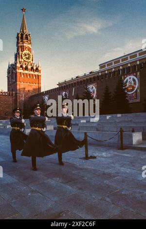 April 1988: Der Wechsel der Ehrenwache des Kreml-Regiments in Lenins Mausoleum vor den Mauern des Kremls auf dem Roten Platz in Moskau, an den Wänden hängen Banner, um den Maifeiertag oder den Internationalen Arbeitertag vorzubereiten. Die Zeit ist 8 Uhr, laut der Uhr auf dem Spassky-Turm des Kremls. Präsident Boris Jelzin entließ die Ehrenwache im Oktober 1993. Stockfoto