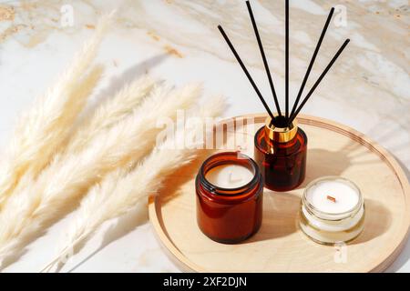 Duftkerzen und Reed Diffusor auf einem Holztablett Stockfoto