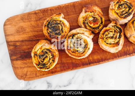 Kürbisspinat- und Käsegebäck-Brötchen auf hölzernem Schneidebrett, frisch gebackene und hausgemachte, gesunde Rezepte Stockfoto