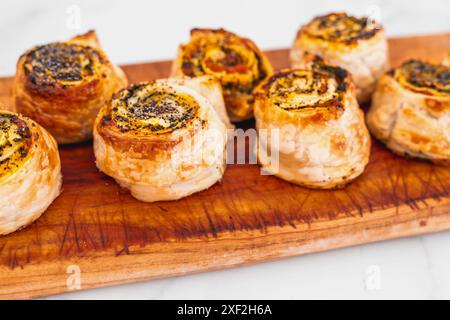 Kürbisspinat- und Käsegebäck-Brötchen auf hölzernem Schneidebrett, frisch gebackene und hausgemachte, gesunde Rezepte Stockfoto