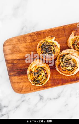 Kürbisspinat- und Käsegebäck-Brötchen auf hölzernem Schneidebrett, frisch gebackene und hausgemachte, gesunde Rezepte Stockfoto