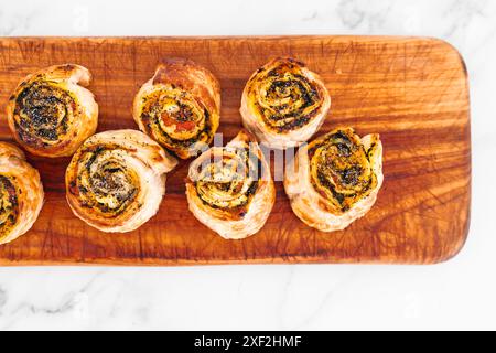 Kürbisspinat- und Käsegebäck-Brötchen auf hölzernem Schneidebrett, frisch gebackene und hausgemachte, gesunde Rezepte Stockfoto