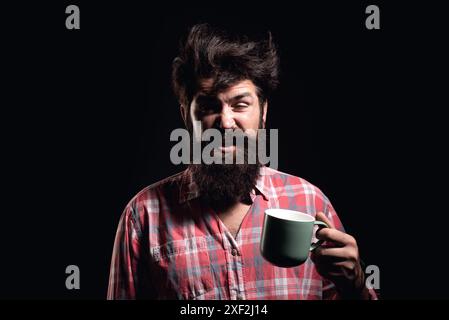 Happy Morning. Mans hält eine Tasse Kaffee. Morgentee. Guten Morgen. Mann mit Teetasse. Hipster-Mann mit einer Tasse Kaffee. Bärtiger Mann, der lächelt, hält Tasse Tee Stockfoto