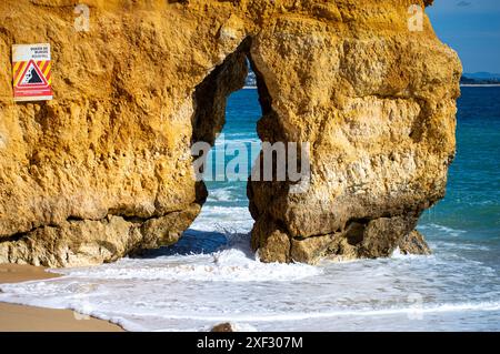 Blick auf die idyllische Naturlandschaft mit felsigem Klippenufer und Wellen, die drauf krachen. Camillo Strand in Lagos. Westküste der Algarve, südlich von Stockfoto