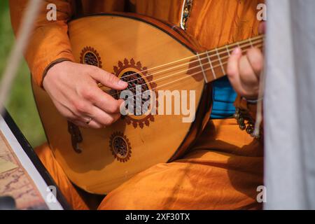 Ein Sänger spielt eine Oud-Laute, Hände auf Streicher in Nahaufnahme Stockfoto