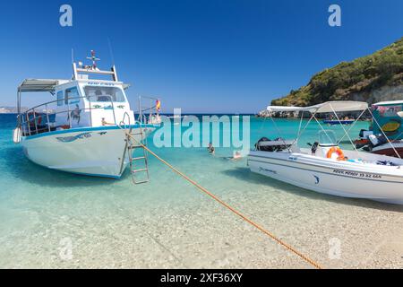 Zakynthos, Griechenland - 16. August 2016: Freizeitmotorboote liegen am Strand vor, Touristen schwimmen in der Nähe Stockfoto