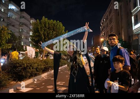 Teheran, Iran. Juni 2024. Eine Frau schaut aus dem Busfenster, während Plakate des iranischen parlamentssprechers Mohammad Bagher Ghalibaf, des Kandidaten für die Präsidentschaftswahlen vom 28. Juni 2024, während eines Wahlkampfs im Zentrum von Teheran, Iran, am Fenster angebracht werden. (Foto: Sobhan Farajvan/Pacific Press/SIPA USA) Credit: SIPA USA/Alamy Live News Stockfoto