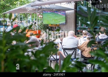 Gäste vor einer Bar in der Kastanienallee in Berlin-Prenzlauer Berg verfolgen das Spiel Türkei gegen Portugal anlässlich des Fußballeuropameisterschaft UEFA EURO 2024. / Gäste vor einer Bar in der Kastanienallee in Berlin-Prenzlauer Berg sehen das Spiel zwischen der Türkei und Portugal anlässlich der Fußball-Europameisterschaft UEFA EURO 2024. UEFA Fußball-Europameisterschaft - Fußballfans *** Gäste vor einer Bar in der Kastanienallee in Berlin Prenzlauer Berg beobachten das Spiel zwischen der Türkei und Portugal anlässlich der Fußball-Europameisterschaft UEFA EURO 2024 Gäste vor der Tür Stockfoto