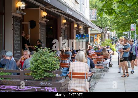 Gäste vor einer Bar in der Kastanienallee in Berlin-Prenzlauer Berg verfolgen das Spiel Türkei gegen Portugal anlässlich des Fußballeuropameisterschaft UEFA EURO 2024. / Gäste vor einer Bar in der Kastanienallee in Berlin-Prenzlauer Berg sehen das Spiel zwischen der Türkei und Portugal anlässlich der Fußball-Europameisterschaft UEFA EURO 2024. UEFA Fußball-Europameisterschaft - Fußballfans *** Gäste vor einer Bar in der Kastanienallee in Berlin Prenzlauer Berg beobachten das Spiel zwischen der Türkei und Portugal anlässlich der Fußball-Europameisterschaft UEFA EURO 2024 Gäste vor der Tür Stockfoto