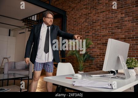 Ein verrückter Geschäftsmann, der am Computer schreit und im Home Office online Meetings macht Stockfoto
