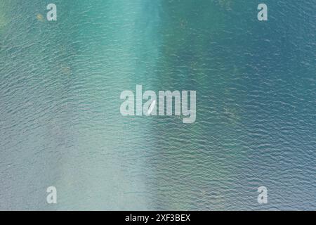 Ein Mann schwimmt im Rummu-Steinbruch, Foto von einer Drohne. Stockfoto