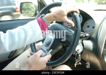 Geschäftsfrau wählt Telefon im Auto Stockfoto