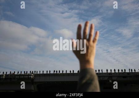 Segler winken vom Deck der USS Ronald Reagan in Sand Diego, Kalifornien. Stockfoto