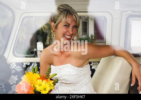 Braut sitzt während der Hochzeit im Auto Stockfoto