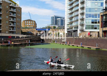 London - 06 04 2022: Paare paddeln auf dem Kanu im Limehouse Basin Stockfoto