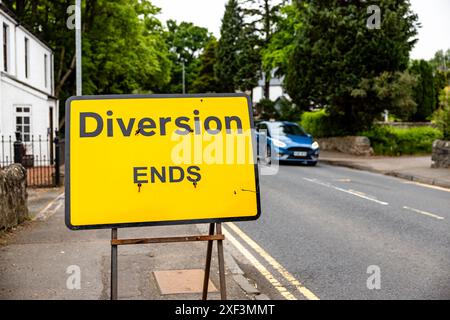 Vorübergehende Umleitung endet in Großbritannien, ein gelbes Zeichen mit schwarzem Text, das anzeigt, dass die UMLEITUNG ENDET. Es liegt an einer Straße neben einer Straße. Stockfoto