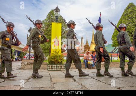 Thailand, Bangkok. Soldaten überqueren den Platz vor dem Wat Phra Kaew Tempel und dem Großen Palast. Stockfoto