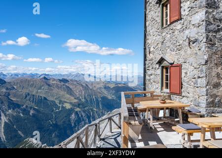 Eine ruhige Szene im Julius Payer House mit einer Terrasse mit Holzbänken und -Tischen, die Besuchern einen atemberaubenden Blick auf die italienischen Ostalpen bietet. Ortles Mountain, Italien Stockfoto