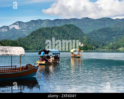 Traditionelle Holzboote oder Pletna fahren von Bled Upper Carniola Slowenien nach Bled Island Stockfoto