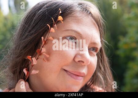 Nahblatt in der Nähe reifer weiblicher Gesichter, Frau 50-55 Jahre alt, Menopause Konzept, Herbst des Frauenlebens, Erforschung altersbedingter Veränderungen, ästhetischer Kosmos Stockfoto