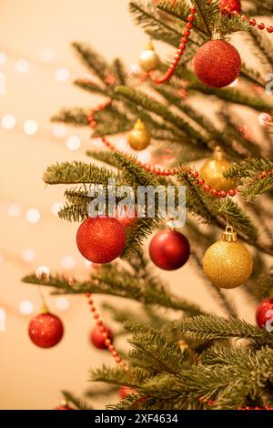Weihnachtsbaum dekoriert mit Girlanden, roten und goldenen Kugeln, Lichter Bokeh Stockfoto