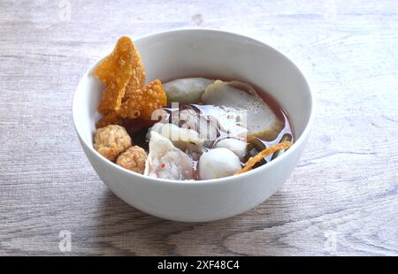 Gekochter Fisch und Garnelenkugeln, ein paar Knödel, die eingelegten Tintenfisch in einer roten Sojasauce auf einer Schüssel belegen Stockfoto