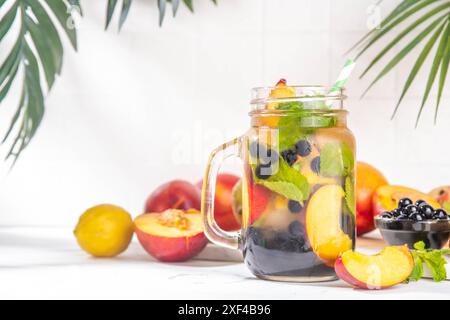 Arnold Palmer Iced Tea mit Boba-Bällen oder Tapioka-Perlen, kalter Peach Lemon Bubble Tea, farbenfrohe Bubble Limonade im maurerglas, mit frischem Obst auf Wi Stockfoto