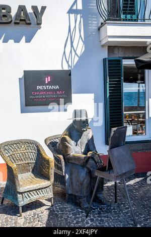 Statue von Sir Winston Churchill zum Gedenken an seine Besuche auf Madeira in der malerischen Bucht von Camara de Lobos . Camara de Lobos Heimat eines lokalen Fischerbootes Stockfoto