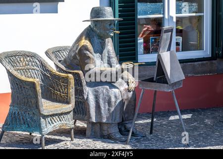 Statue von Sir Winston Churchill zum Gedenken an seine Besuche auf Madeira in der malerischen Bucht von Camara de Lobos . Camara de Lobos Heimat eines lokalen Fischerbootes Stockfoto