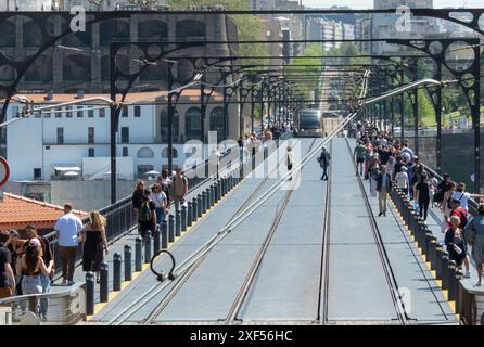 PORTO, PORTUGAL - 24. APRIL 2024: Fußgänger überqueren die Bahn vor der U-Bahn auf der Luis 1 Brücke in Porto, Portugal Stockfoto
