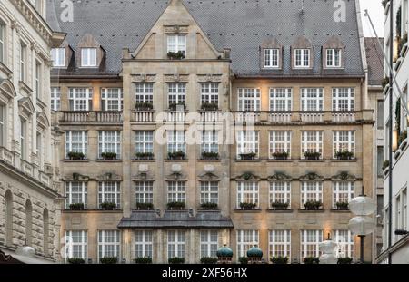 München, Deutschland - 21. Dezember 2023 - Außenarchitektur des Kaufingerstr11a-Gebäudes mit Fenstern mit Blumentöpfen. Traditionelle bayerische Architektur. S Stockfoto