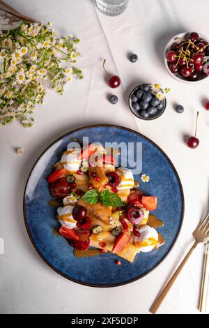 Köstliche Crepes mit Sommerbeeren und Toppings, gerollte dünne Pancakes mit Hüttenkäse Füllung auf einem Teller Stockfoto