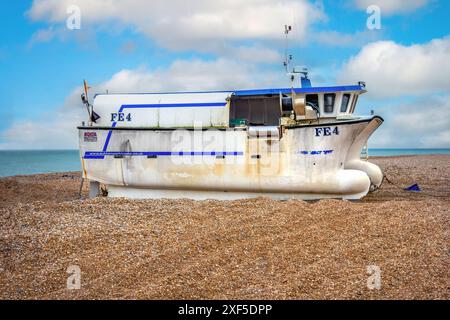 Ein Seitenblick auf ein weiß-blaues Katamaran-Fischerboot namens „FE4 Doreen T“, das am Kiesstrand von Dungeness vor Anker liegt Stockfoto