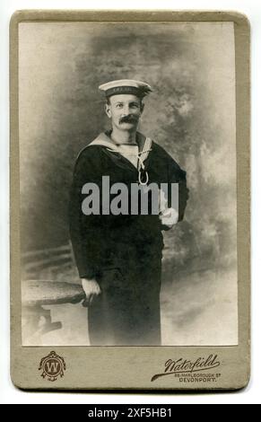 Devon. Ca. 1906: Ein Kabinettporträt eines britischen Seemanns der Royal Naval Reserve, aufgenommen um 1906 vom Fotografen W. H. Waterfield aus 38 Marlborough Street, Devonport, Devon, England. Der Seemann trägt das R-Logo des Reservisten auf seinem Ärmel und die Tally auf seiner Kappe zeigt an, dass er Mitglied der Besatzung des Panzerkreuzers der Devonshire-Klasse der Royal Navy ist, H.M.S. Argyll. Das Schiff wurde im März 1904 gestartet und im Dezember 1905 in Devonport am fertiggestellt. Im Oktober 1915 lief sie auf Grund und wurde zerstört. Stockfoto