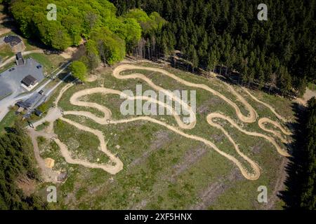 Blick aus der Vogelperspektive, Green Hill Bikepark, Mountainbikeweg im Stadtteil Gellinghausen, Serpentine bergab, umgeben von Wald, Wiesen und fels Stockfoto