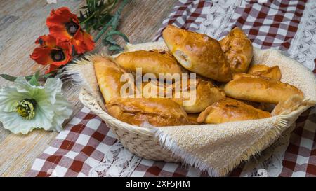 Kuchen mit Füllung in einen Korb auf einem Holztisch. Landmotiv. Stockfoto