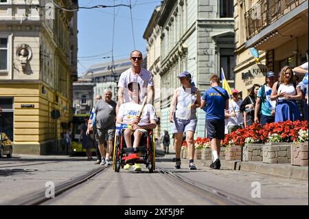 LEMBERG, UKRAINE - 30. JUNI 2024 - finnische Freiwillige, die innerhalb von 42 Tagen 1.561 Kilometer von Helsinki nach Lemberg gelaufen sind und im Rahmen des Wohltätigkeitswegs Relay to Ukraine mehr als 180.000 Euro für Krankenwagen und medizinische Ausrüstung für die Ukraine gesammelt haben, absolvieren ihre Reise in Lemberg, Westukraine. Stockfoto