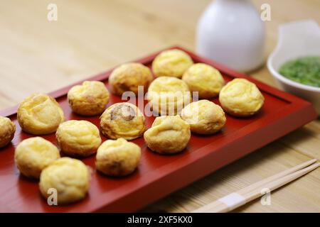 Hausgemachte Akashiyaki (der Ursprung von Takoyaki) sind runde Knödel, die aus eierreichem Teig und Tintenfisch hergestellt werden. Vor dem Essen in Dashi getaucht. Japanisches Essen Stockfoto