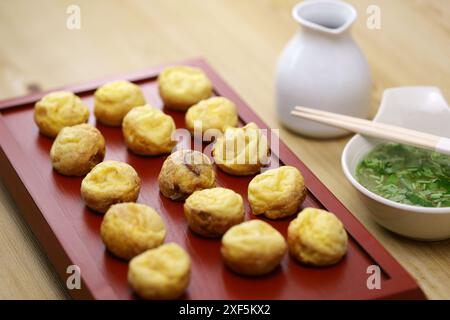 Hausgemachte Akashiyaki (der Ursprung von Takoyaki) sind runde Knödel, die aus eierreichem Teig und Tintenfisch hergestellt werden. Vor dem Essen in Dashi getaucht. Japanisches Essen Stockfoto