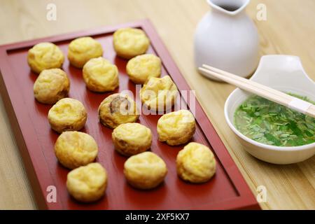 Hausgemachte Akashiyaki (der Ursprung von Takoyaki) sind runde Knödel, die aus eierreichem Teig und Tintenfisch hergestellt werden. Vor dem Essen in Dashi getaucht. Japanisches Essen Stockfoto