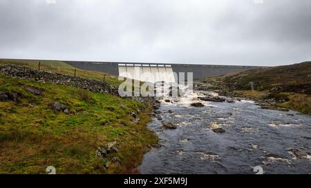 Der Staudamm des Cow Green Reservoir leitet an einem regnerischen Herbsttag Hochwasser über den Fluss Tees über dem Wasserfall Cauldron Snout ab Stockfoto