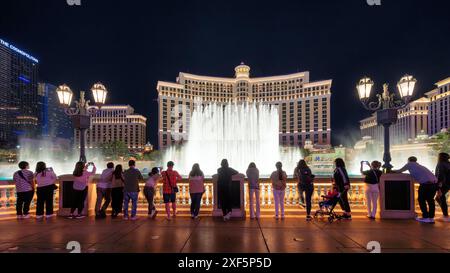 Die Leute genießen den Blick auf die tanzenden Springbrunnen im Bellagio Hotel and Casino bei Nacht Stockfoto