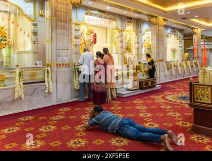 Bangkok, Thailand. Juni 2024. Ein Mann, der auf dem Boden lag, sein Gesicht zum Boden gerichtet und betete, im Dev Mandir Tempel Hindu Samaj. Bangkok ist ein Schmelztiegel der Kulturen, Religionen und Bräuche. Es ist überwiegend buddhistisch und hat eine Geschichte der Begrüßung von Siedlern mit unterschiedlichen Glaubensrichtungen. Bangkok beherbergt Schreine, Tempel und Kirchen, in denen Menschen verschiedener Glaubensrichtungen um Glück und Glück beten. (Foto: Nathalie Jamois/SOPA Images/SIPA USA) Credit: SIPA USA/Alamy Live News Stockfoto